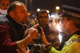 A person argues with a police officer while waiting to get on a ferry in Dover, Britain.
