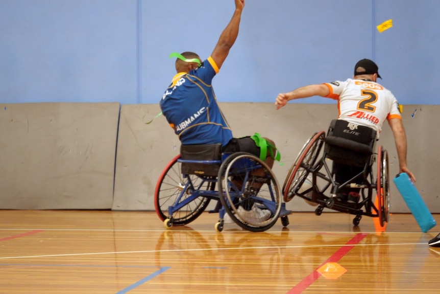 Two men in wheelchairs on basketball court