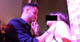 Julien Blanc grabs a woman's throat and gestures that she keep quiet.