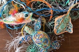 A fish, turtle and stingray made nets on top of a pile of assorted ropes.