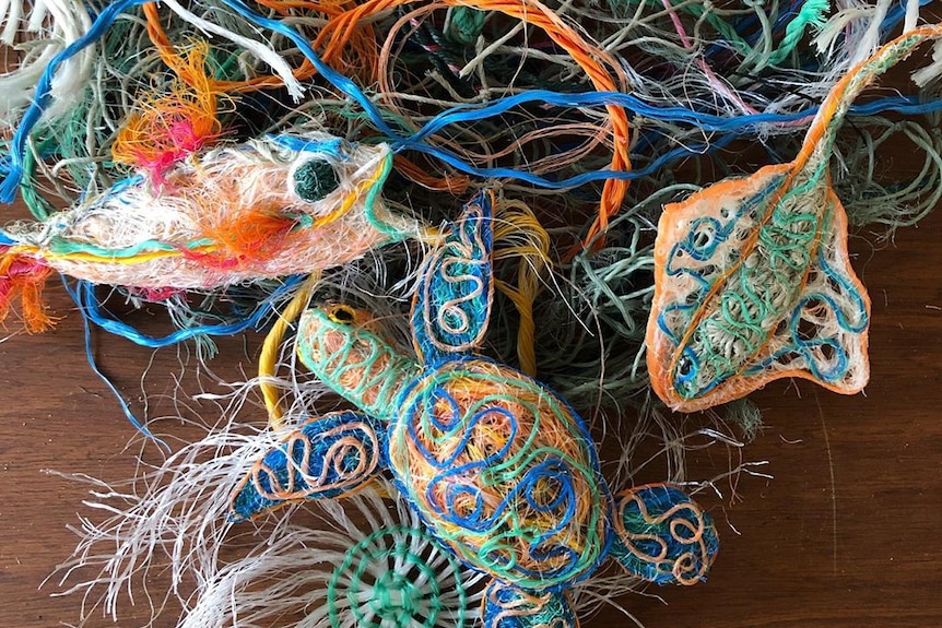A fish, turtle and stingray made nets on top of a pile of assorted ropes.
