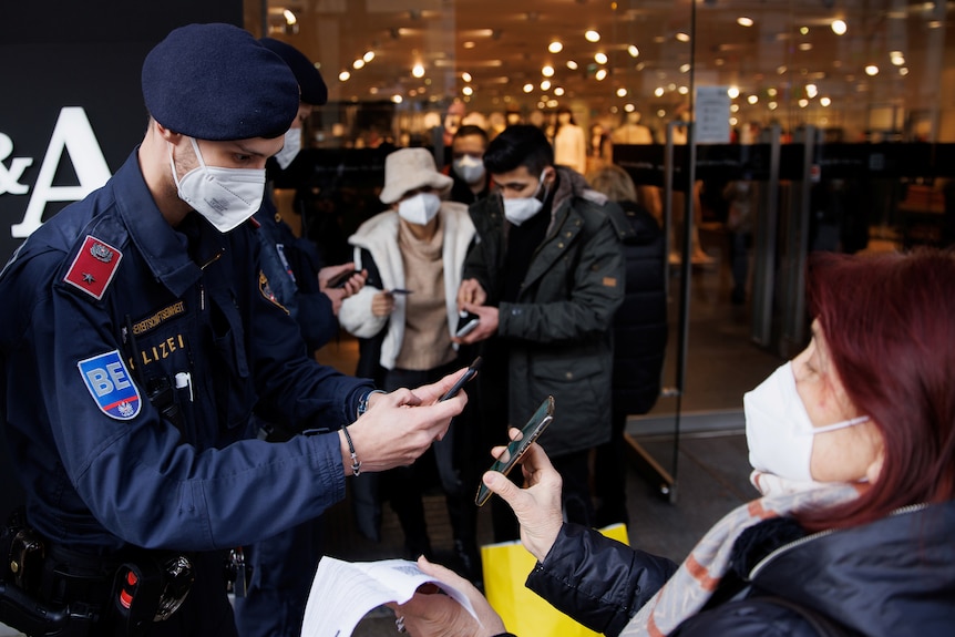 Police officers check the vaccination status of shoppers in Vienna, Austria.