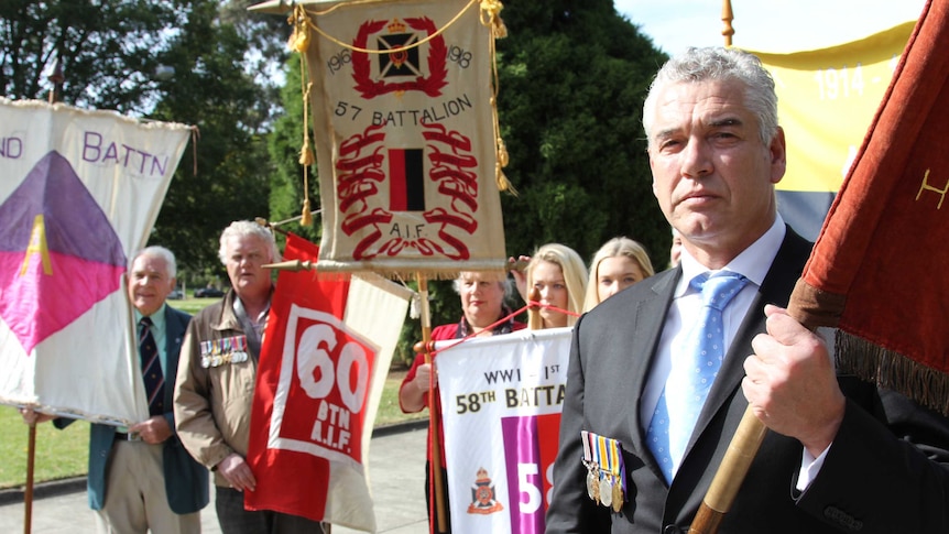 WWI descendants with battalion banners at the Shrine of Remembrance