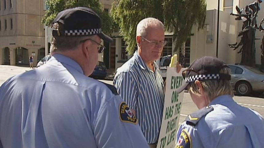 Lone anti-abortion protester Graham Preston is arrested by police in Hobart.