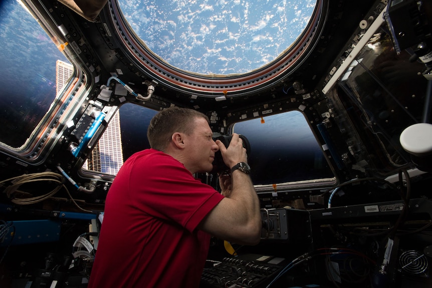 A NASA astronaut takes a photo inside the Space Station's Cupola module