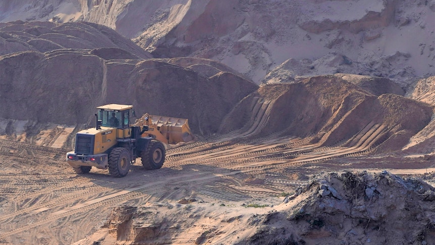 Heavy machinery at a dusty mine site.