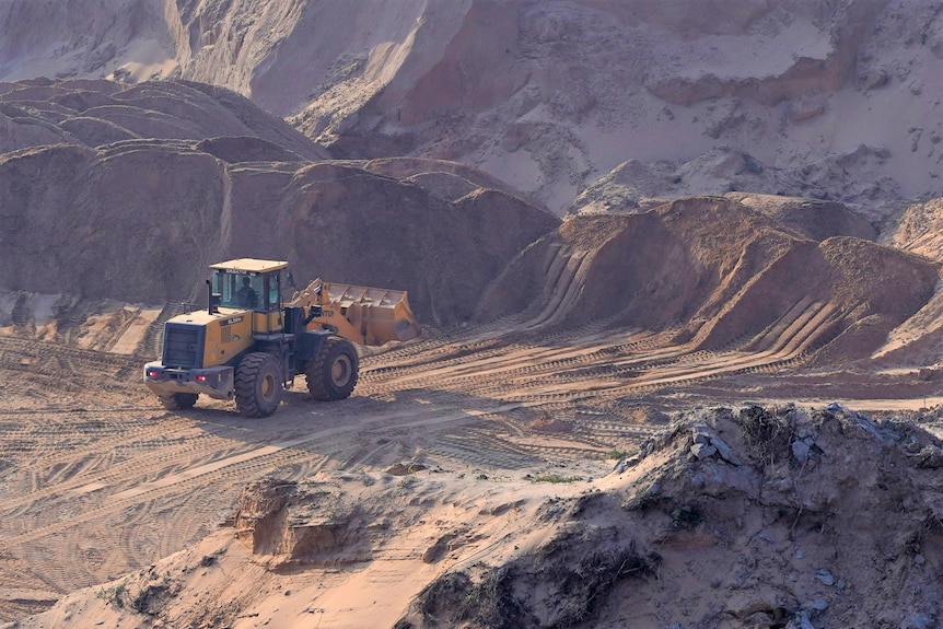 Heavy machinery at a dusty mine site.