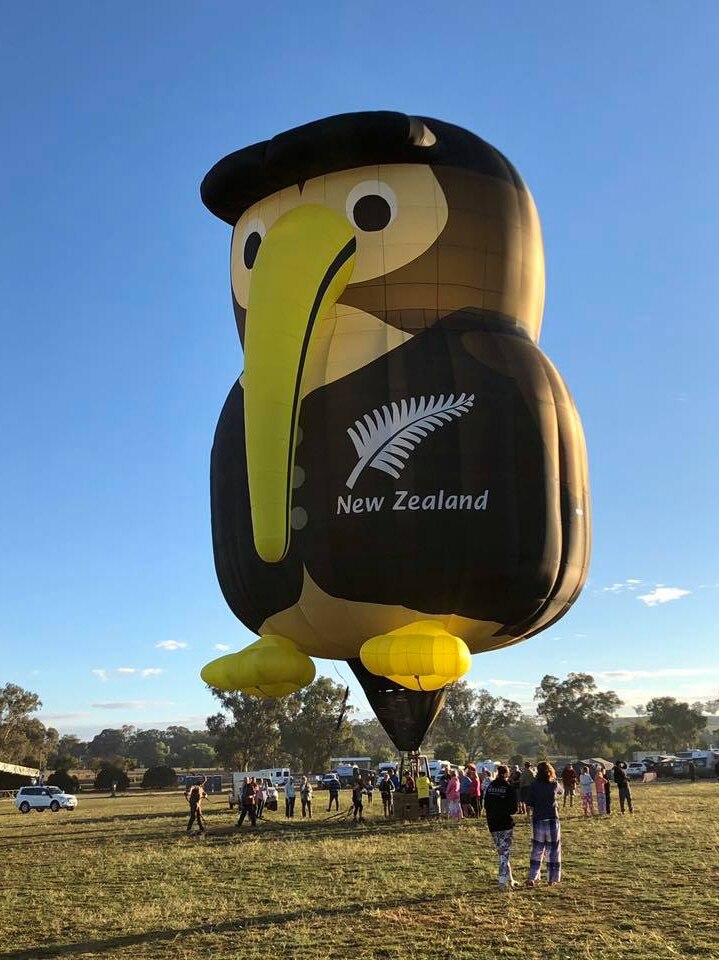 A hot air balloon in the shape of a kiwi bird dressed in black with New Zealand and a silver fern emblazoned on it.