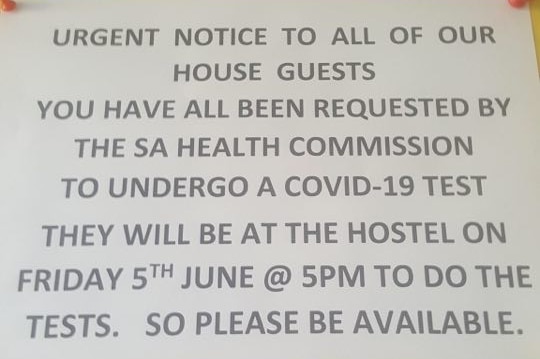 A flyer pinned up in a hostel asking backpackers to take a COVID-19 test.