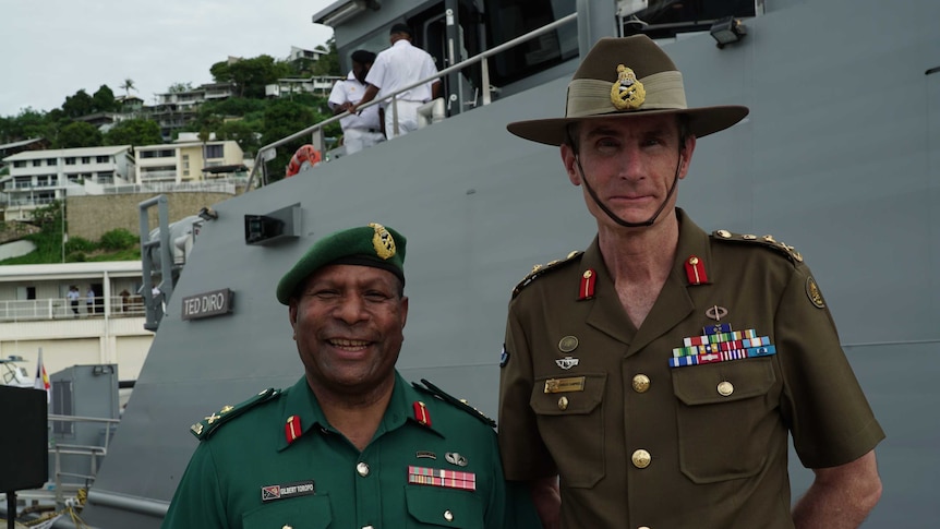 General Angus Campbell and PNG Defence Force Commander Gilbert Toropo pose in front of a naval ship.
