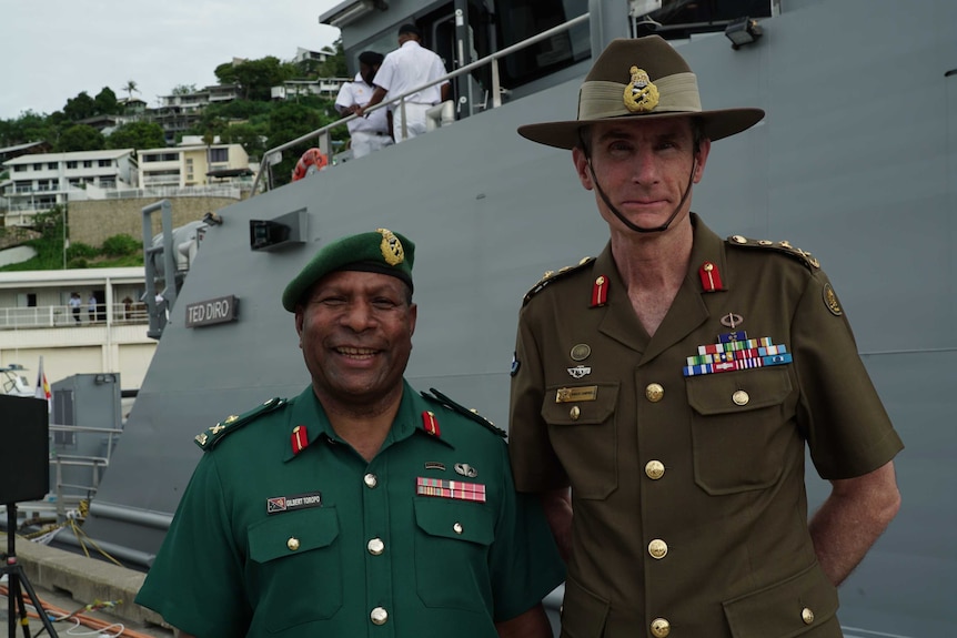 General Angus Campbell and PNG Defence Force Commander Gilbert Toropo pose in front of a naval ship.