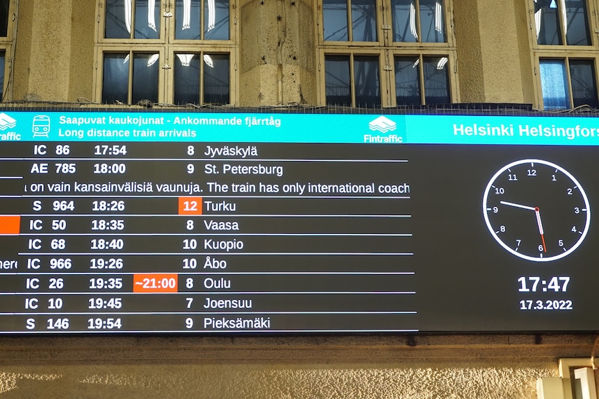 A board displays a series of train times.
