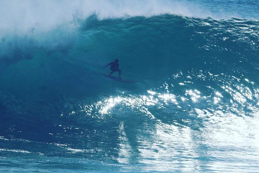 A surfer in the middle of a giant wave