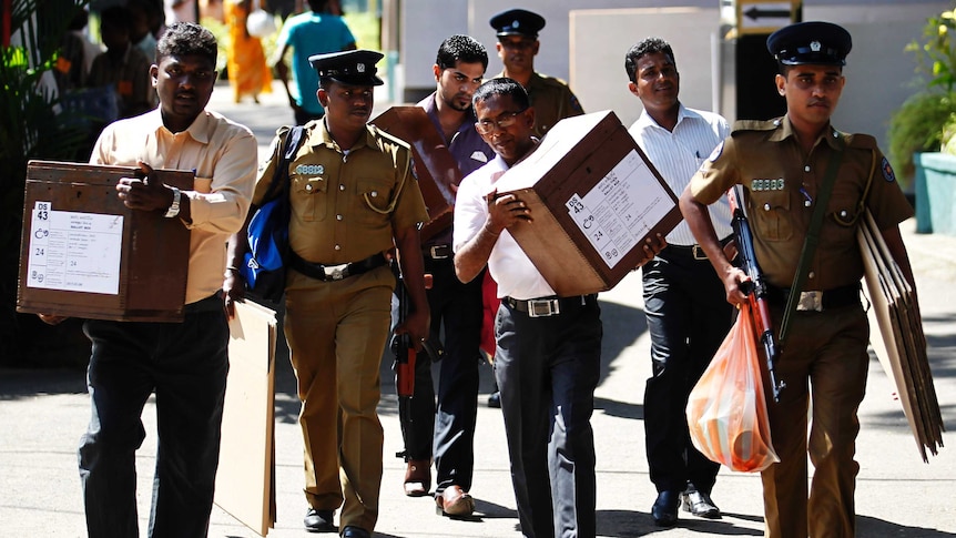 Sri Lankan police carrying ballot boxes