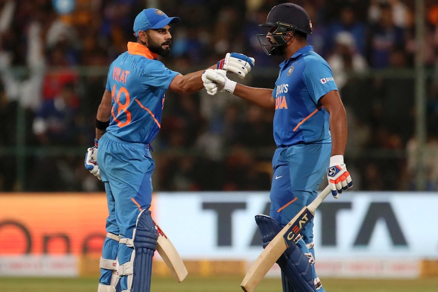 Virat Kohli and Rohit Sharma fist-bump in the middle of the pitch.