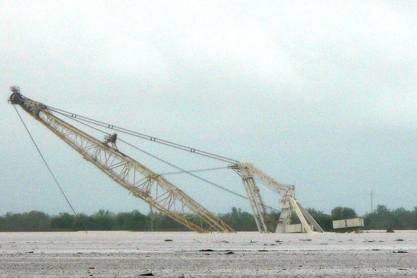 A dragline sits submerged in floodwaters