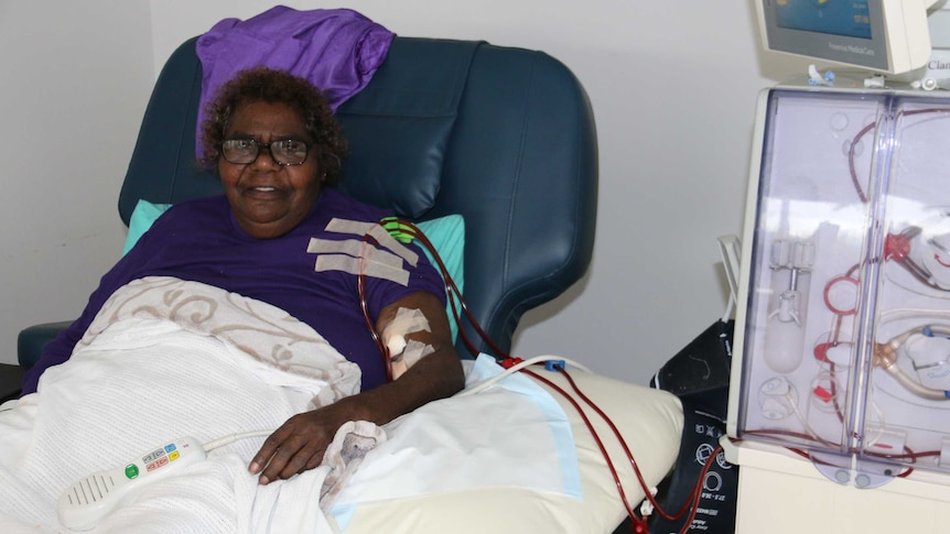 An Indigenous woman in a dialysis chair receiving dialysis with a pump to her side.