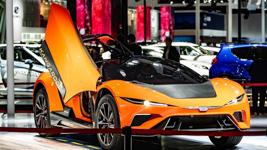 A sporty orange electric electric vehicle with the door up