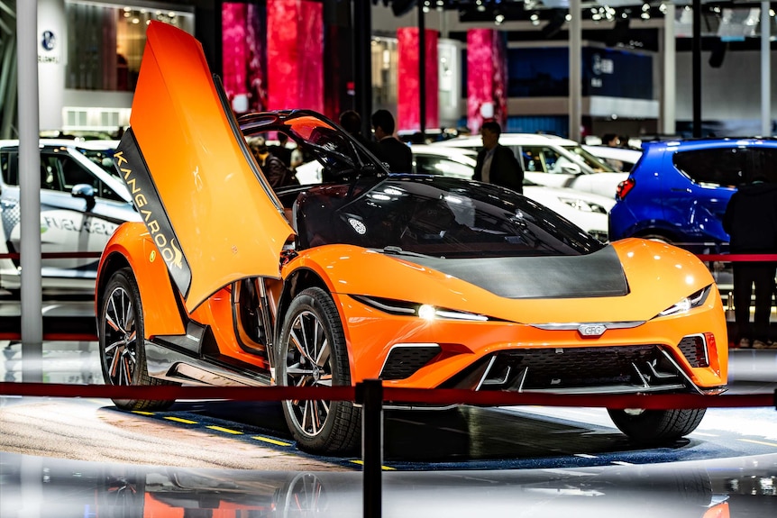 A sporty orange electric electric vehicle with the door up