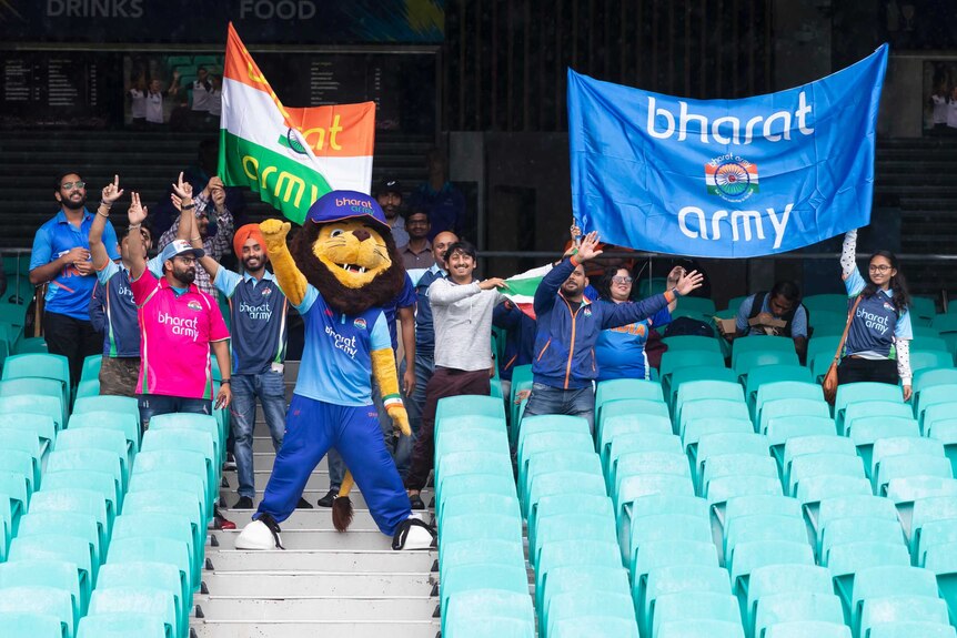 Indian fans, including a mascot, stand in the crowd as rain falls at the SCG.