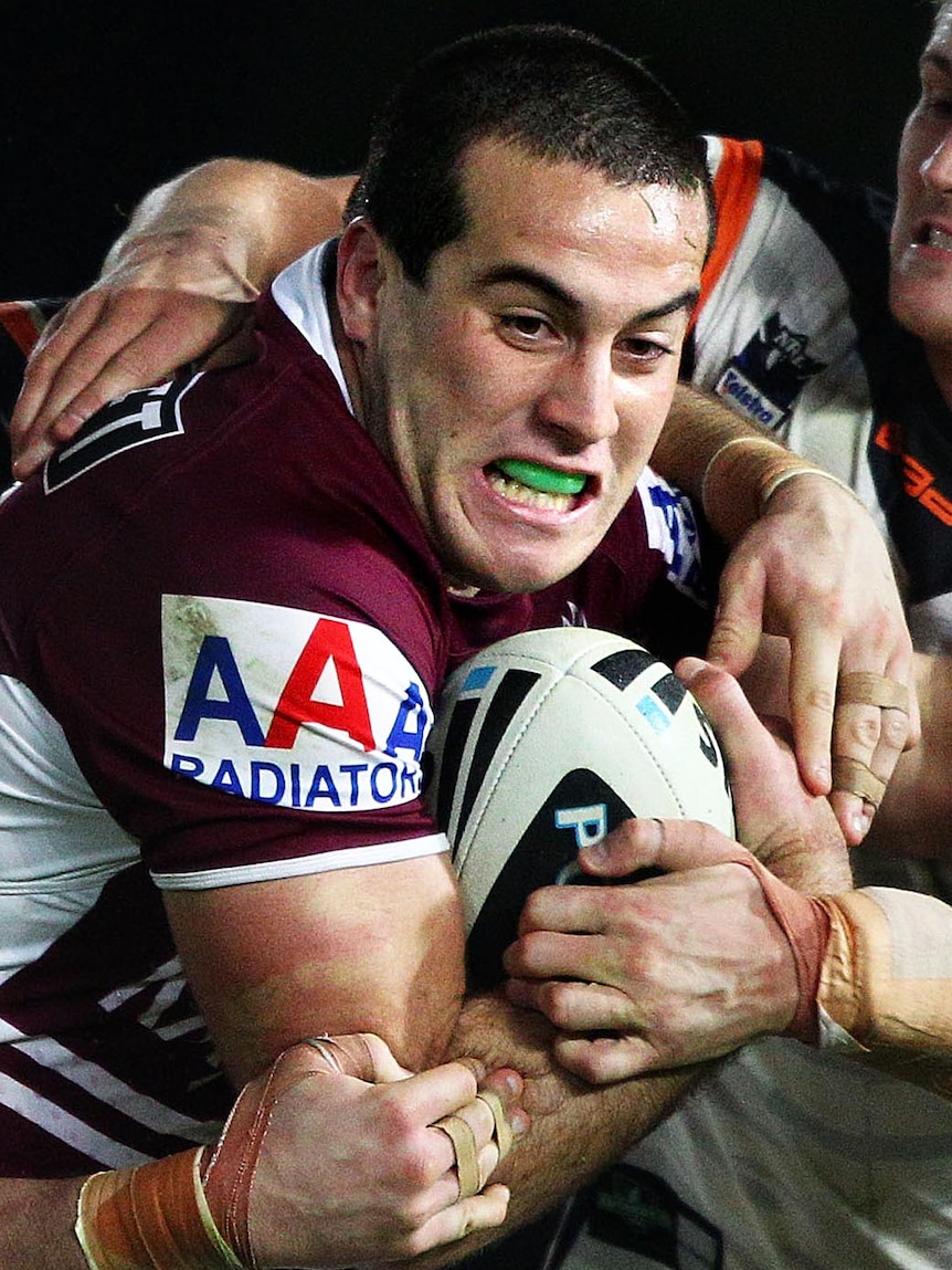 Michael Oldfield of the Sea Eagles is tackled.