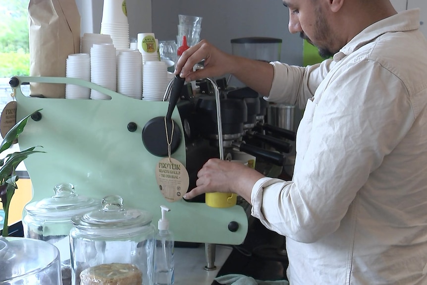 a man at a machine making coffee