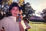 An old photo of Josie Bober when she was a young child, looking into the camera and drinking a box of juice.
