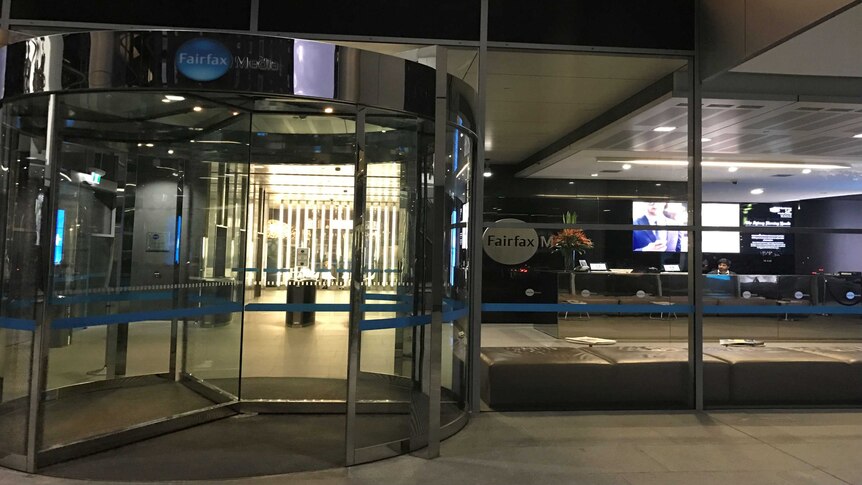 An image shows a rotating door at night time at the entrance of the fairfax building in sydney