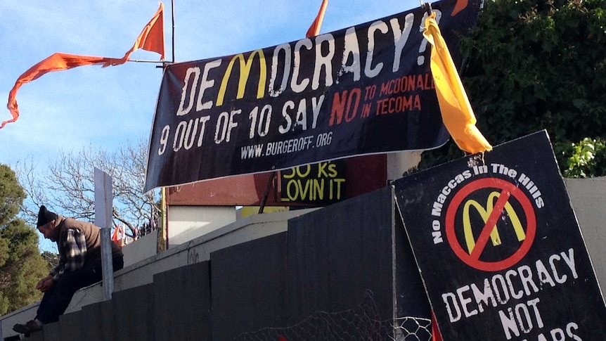 A protester on the roof of the McDonalds being built at Tecoma