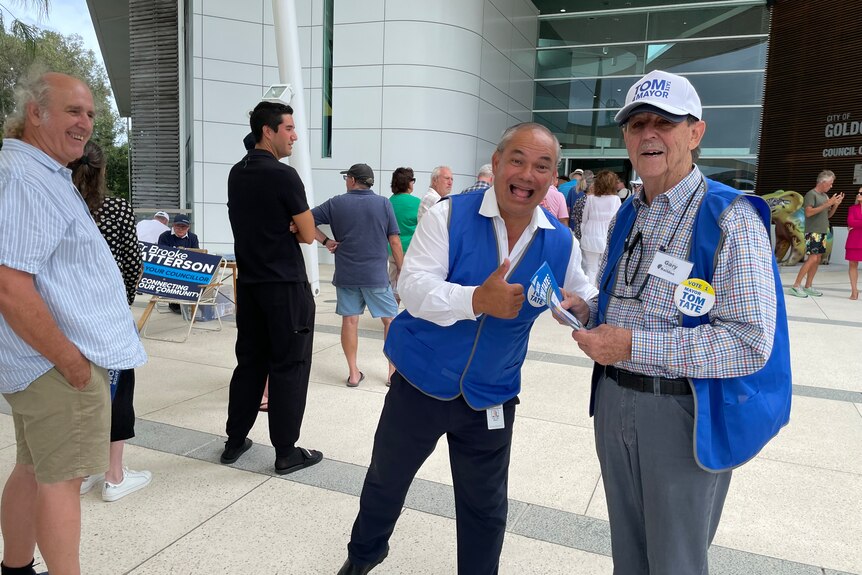 An image of Gold Coast mayor Tom Tate doing a 'thumbs up' at a polling booth in the Gold Coast with former mayor Gary Baildon