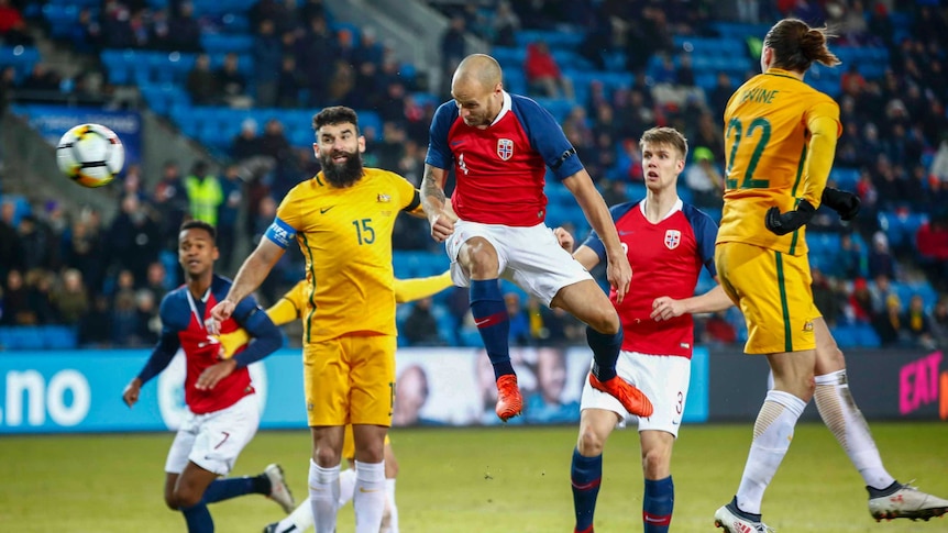 Tore Reginiussen of Norway heads in Norway's second goal with Australia's Jackson Irvine.