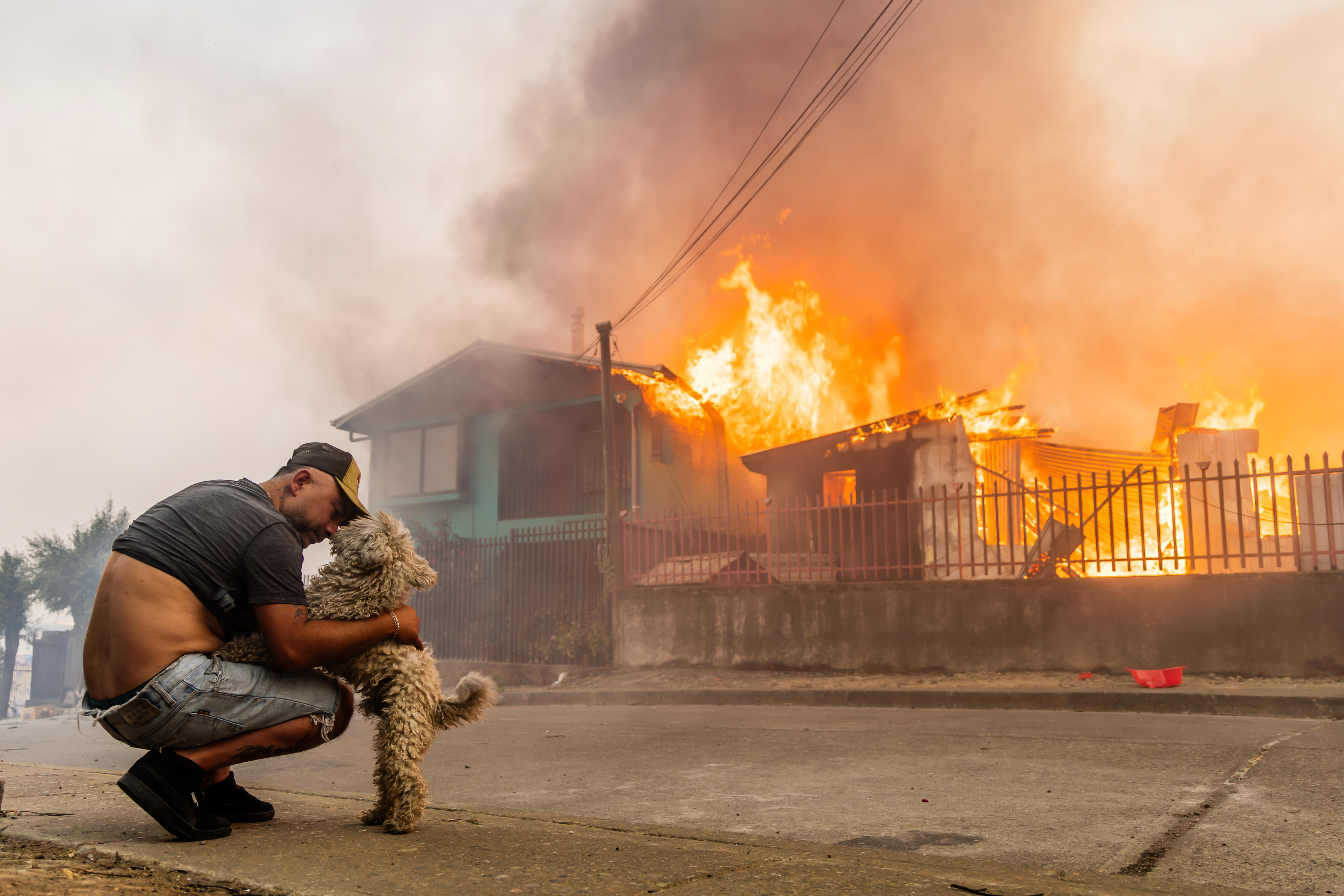 Un miembro de la familia González acaricia a su perro después de que la casa de la familia se incendiara.