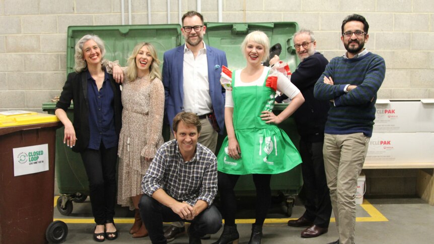 The six presenters and the host of ABC Radio Melbourne’s War On Waste comedy debate gather around a large green dumpster.