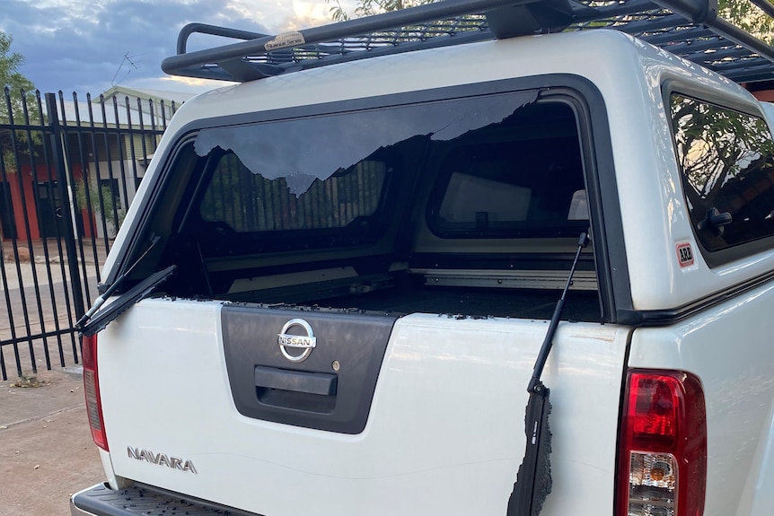 The smashed back window of a white ute