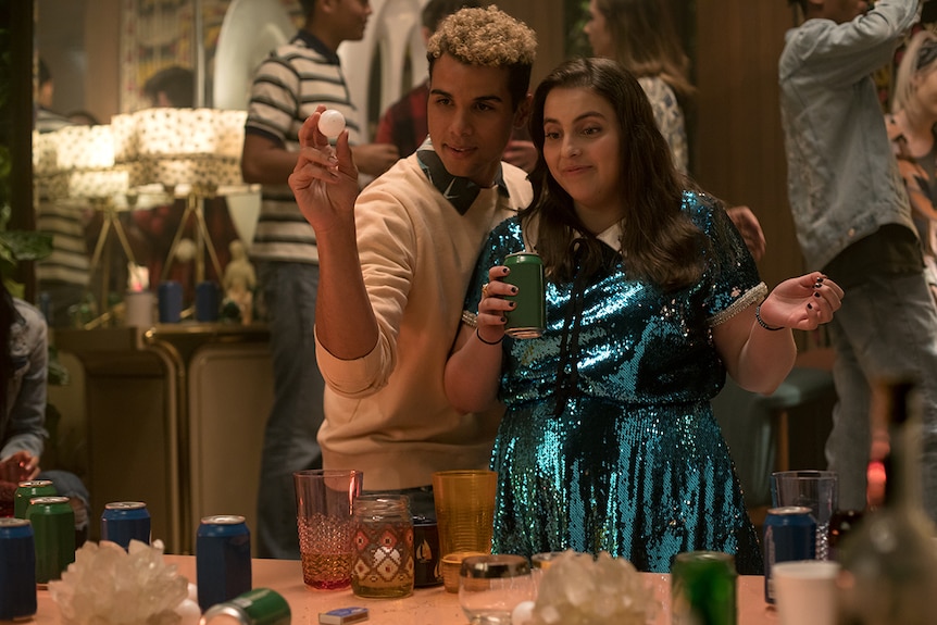 Colour film still of Mason Gooding and Beanie Feldstein at a house party in 2019 film Booksmart.