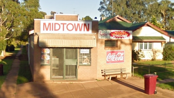 A small brick corner store with a large sign above an awning that says MIDTOWN.