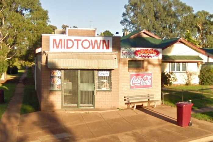 A small brick corner store with a large sign above an awning that says MIDTOWN.