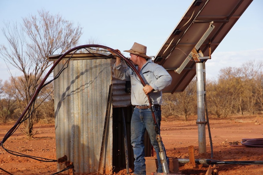 A station manager repairs a water supply.