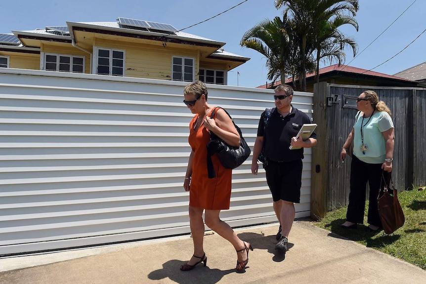 Officials from the Department of Education and Training leave a Moorooka house used as a family daycare