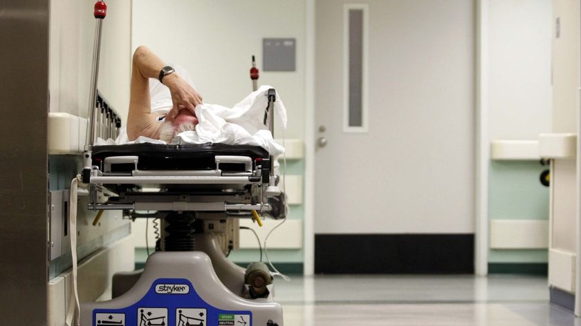 An elderley man in a hospital bed.