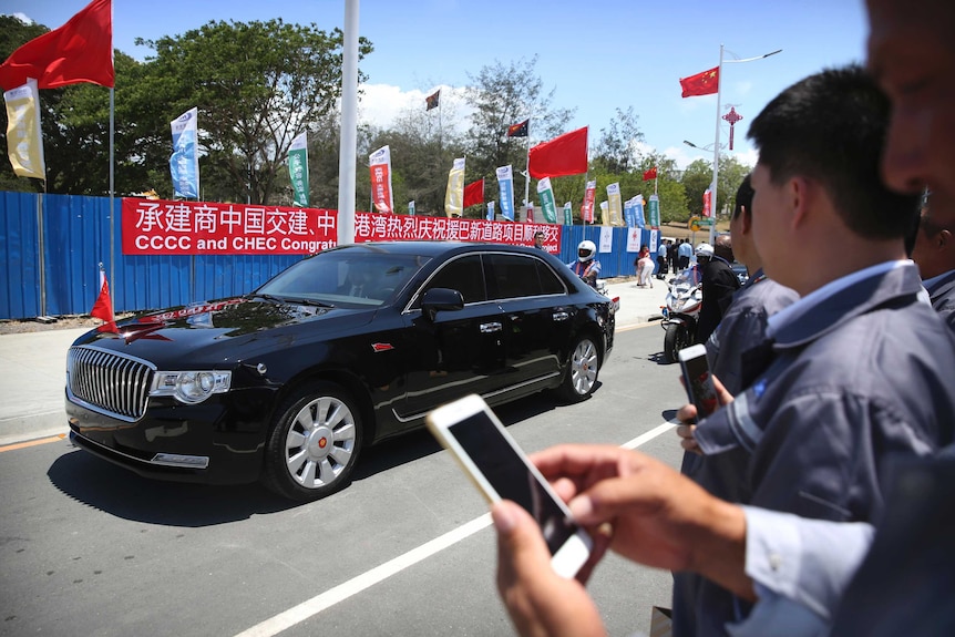 The Chinese Presidential motorcade passes through Port Moresby streets flanked by security on motorbikes.