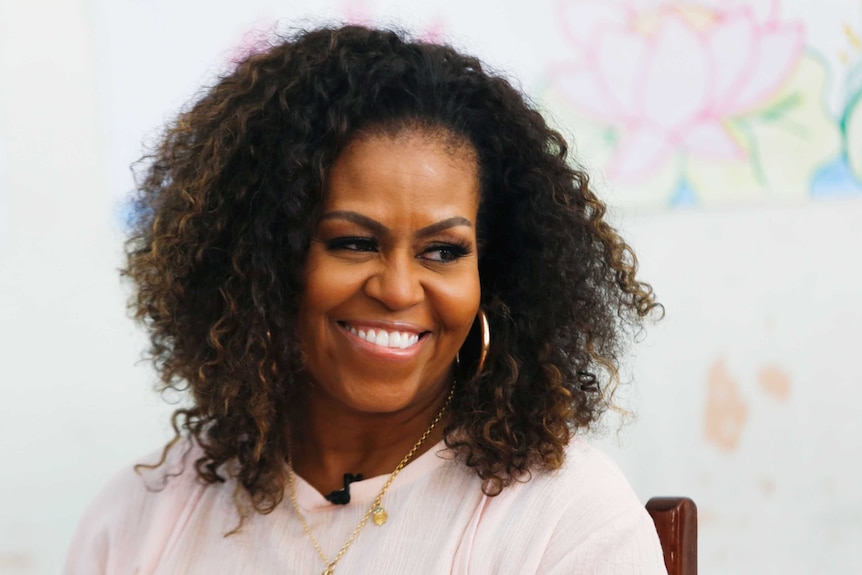 Former first lady Michelle Obama smiles while looking off camera.