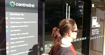 A woman walks past a Centrelink office in Marrickville.