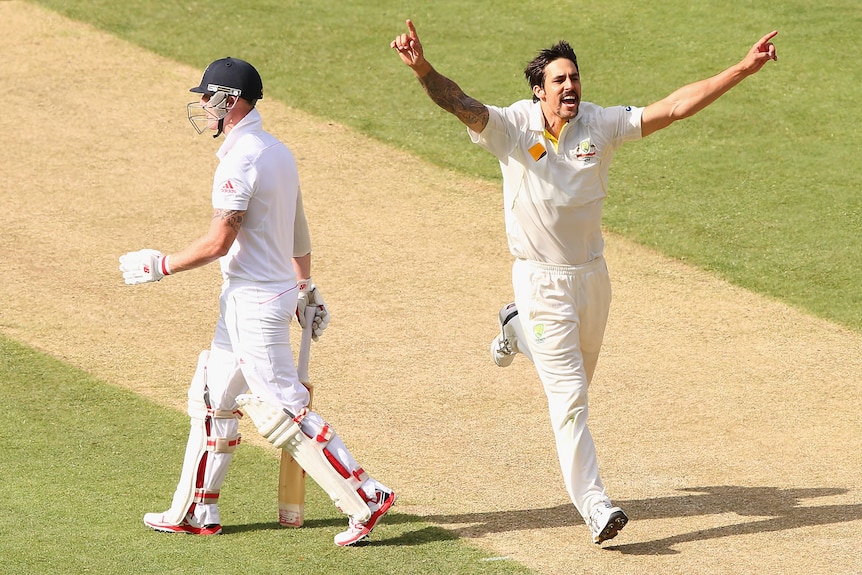 Mitchell Johnson runs with his arms outstretched past Ben Stokes who walks off in batting kit