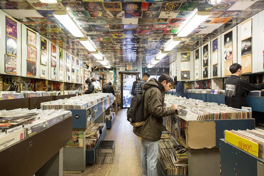 People in a record store comb through the different records for sale