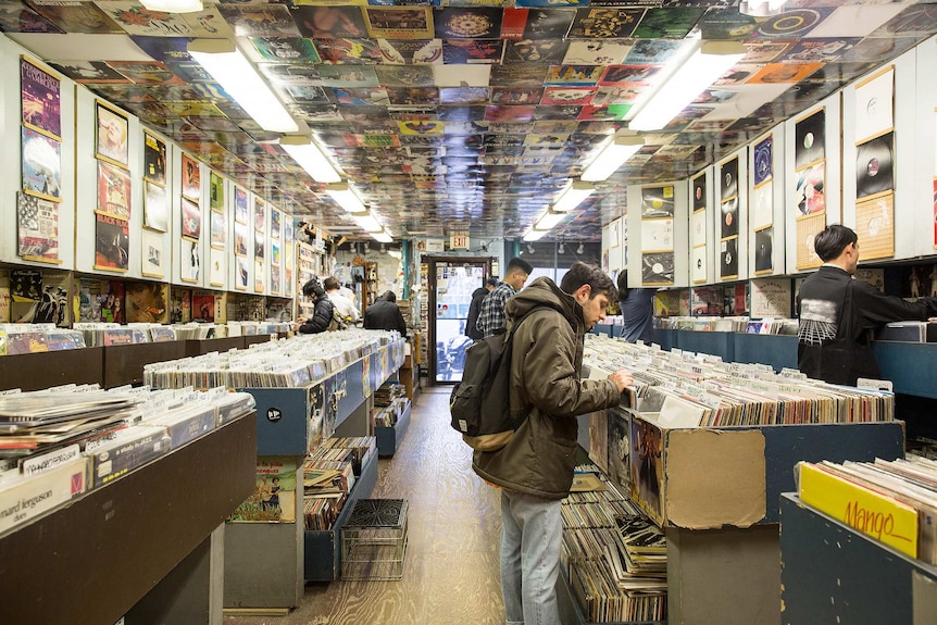 People in a record store comb through the different records for sale