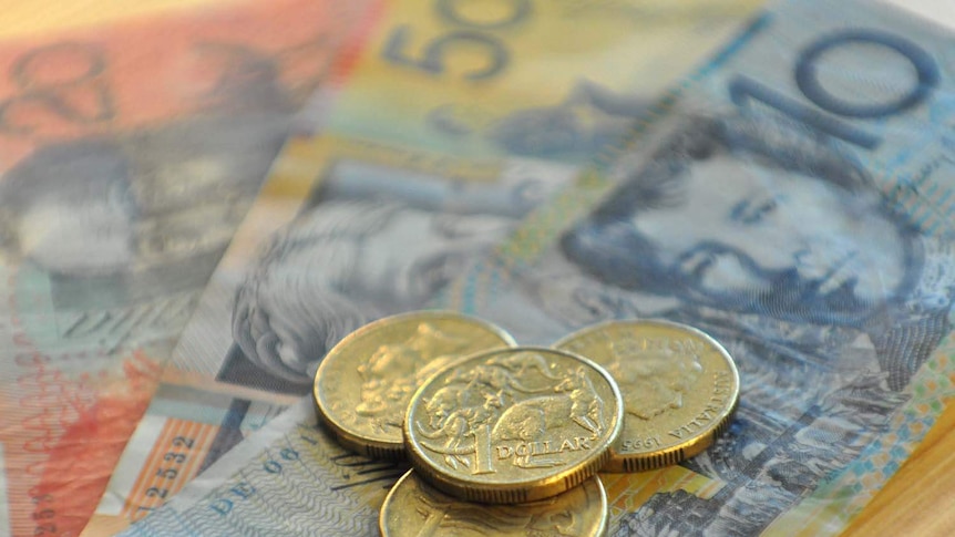 Australian currency notes and coins spread across a table.