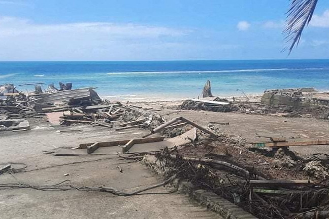 Una vista de una playa y escombros tras la erupción volcánica y el tsunami