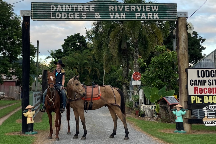 Libby on horseback with a pack horse out front of a caravan horse. 