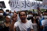 Residents take part in a rally demanding government compensation